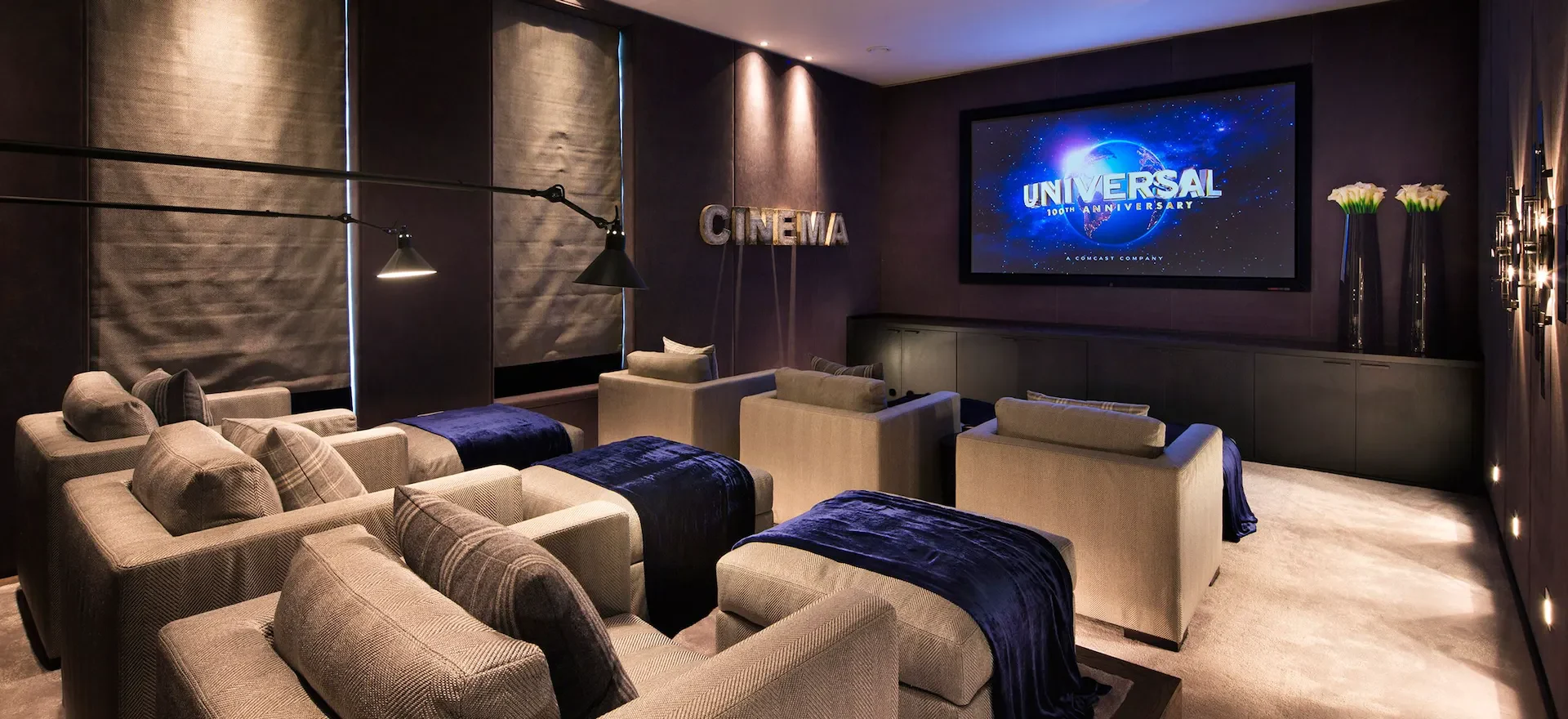 Home cinema with tiered seating and a large projection screen