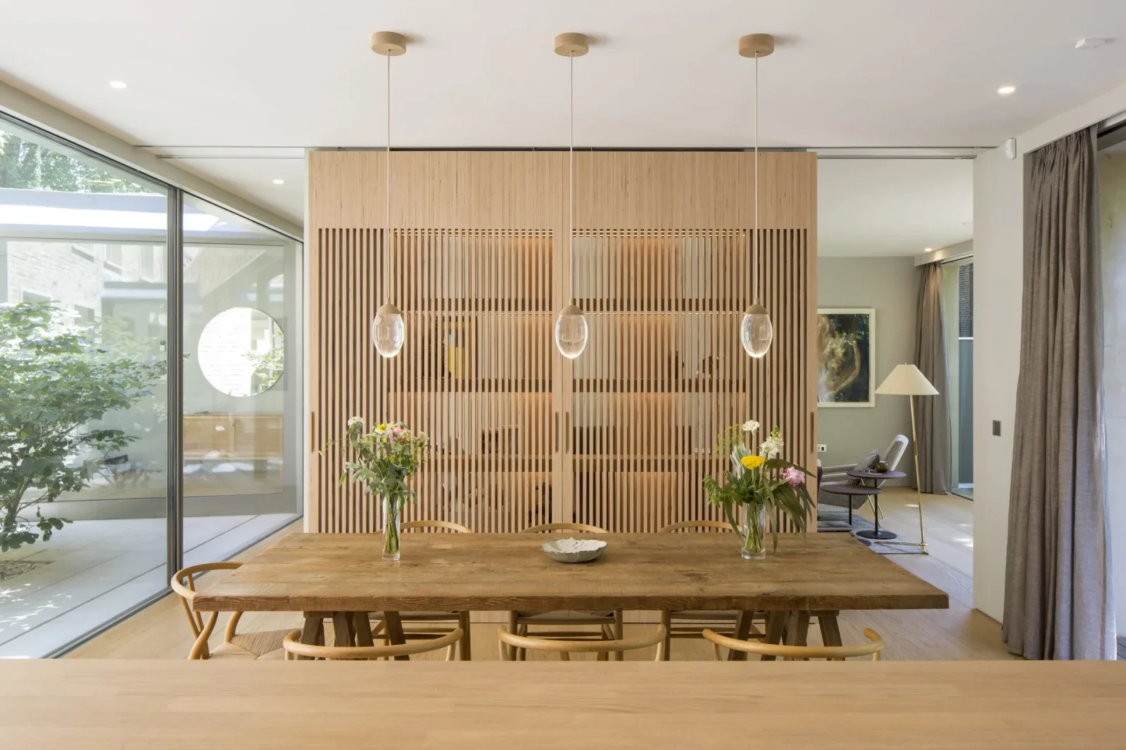 Dining space illuminated by three pendants and ceiling downlights