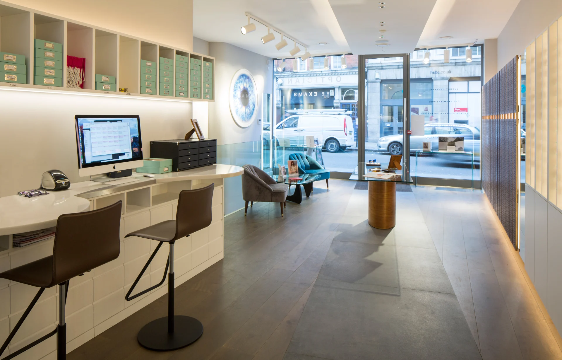 Retail interior with a white counter, shelving and Lutron-controlled lighting