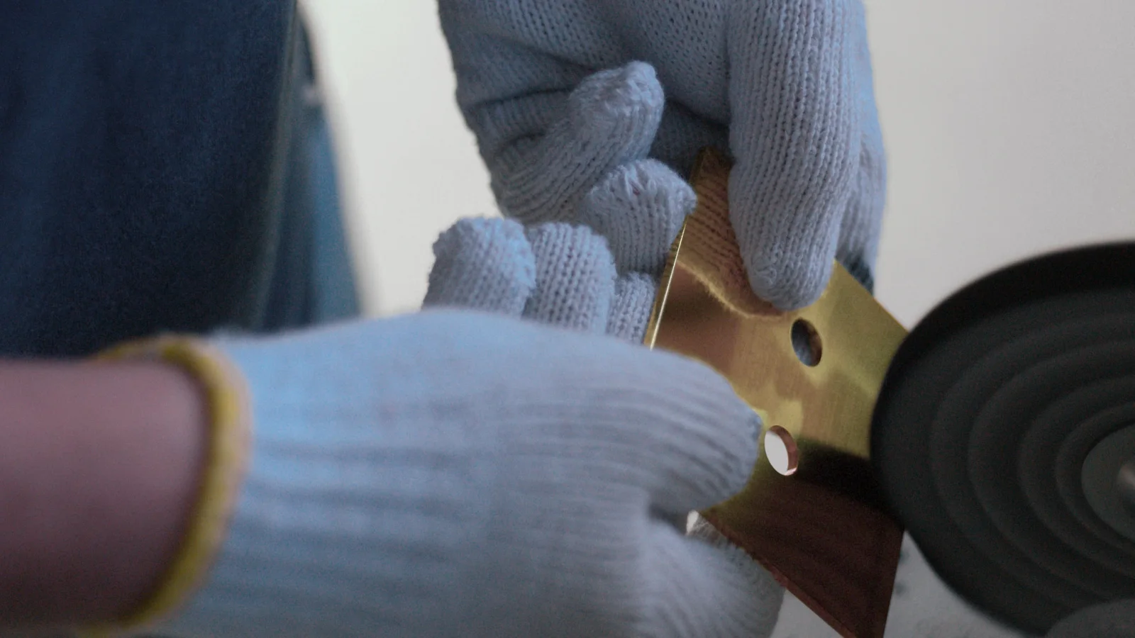 A metal Alisse faceplate being polished during manufacture